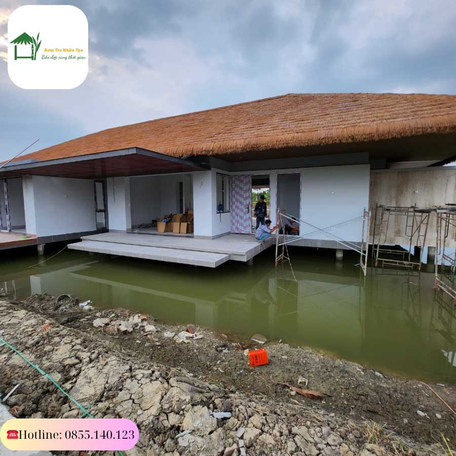 Toàn cảnh căn villa nổi bật với hệ mái cót ép nhân tạo phản chiếu trên mặt nước.