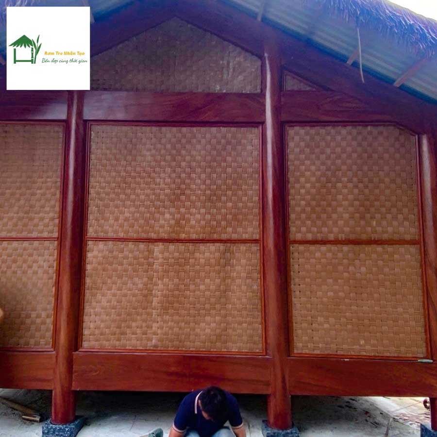 Tường nhà homestay ốp toàn bộ bằng phên tre nhân tạo, đội thi công đang hoàn thiện phần cuối.