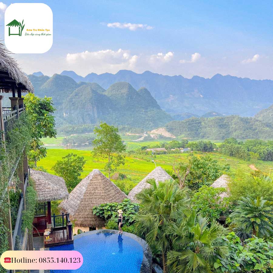 View từ trên cao với mái rơm nhân tạo bao phủ resort giữa thung lũng.