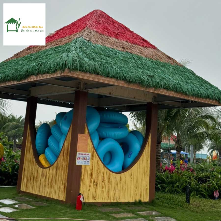 Nhà gỗ mái rơm nhân tạo có tranh mặt người trang trí bên ngoài.