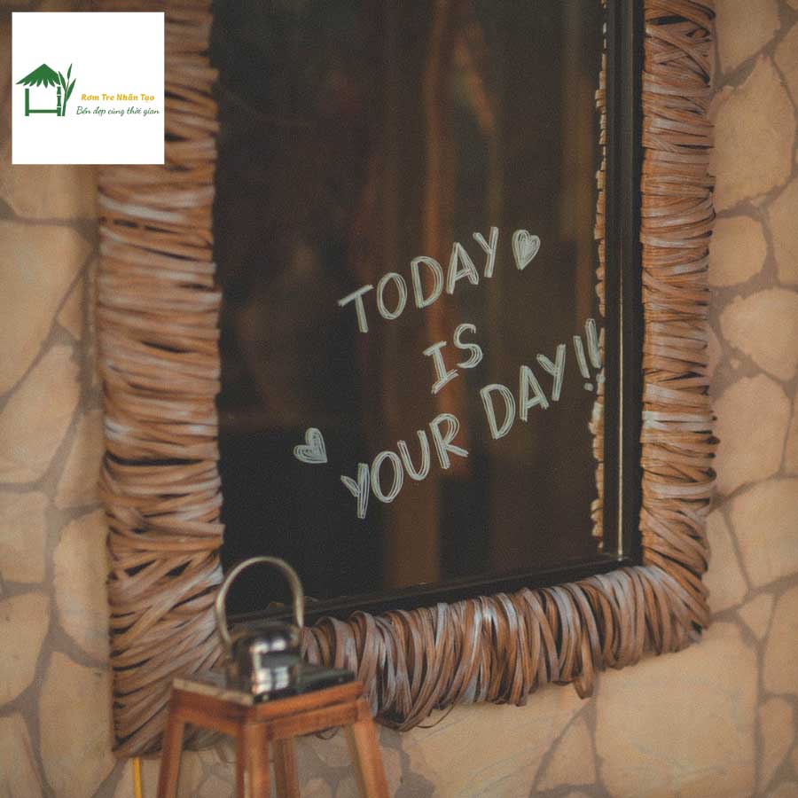 Tấm biển gỗ trang trí treo trên tường đá, có chữ “Today is a good day” khắc trắng.