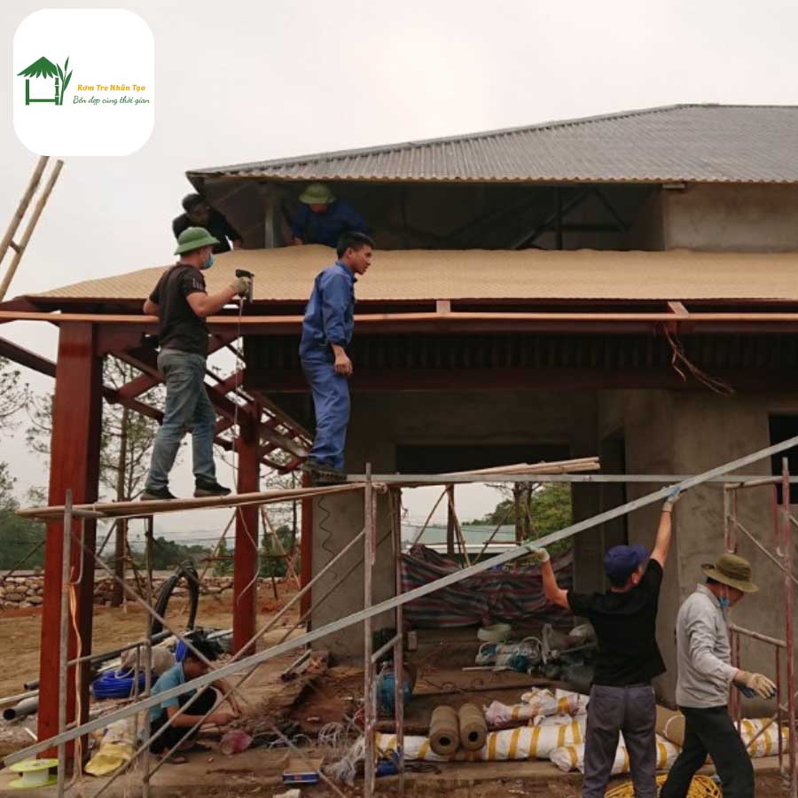 Công nhân thi công nhà sàn với mái rơm nhân tạo.